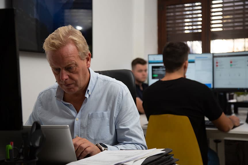 A Selva Digital colleague working with a laptop and documents at an office desk