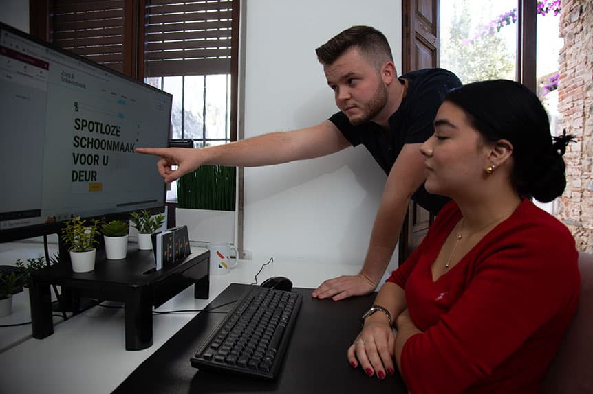 A Selva Digital colleague pointing at a result on screen while a colleague takes notes