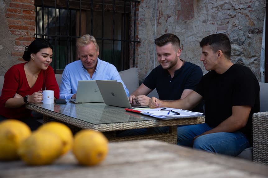 El equipo de Selva Digital trabajando con portátiles alrededor de una mesa en el patio de la oficina