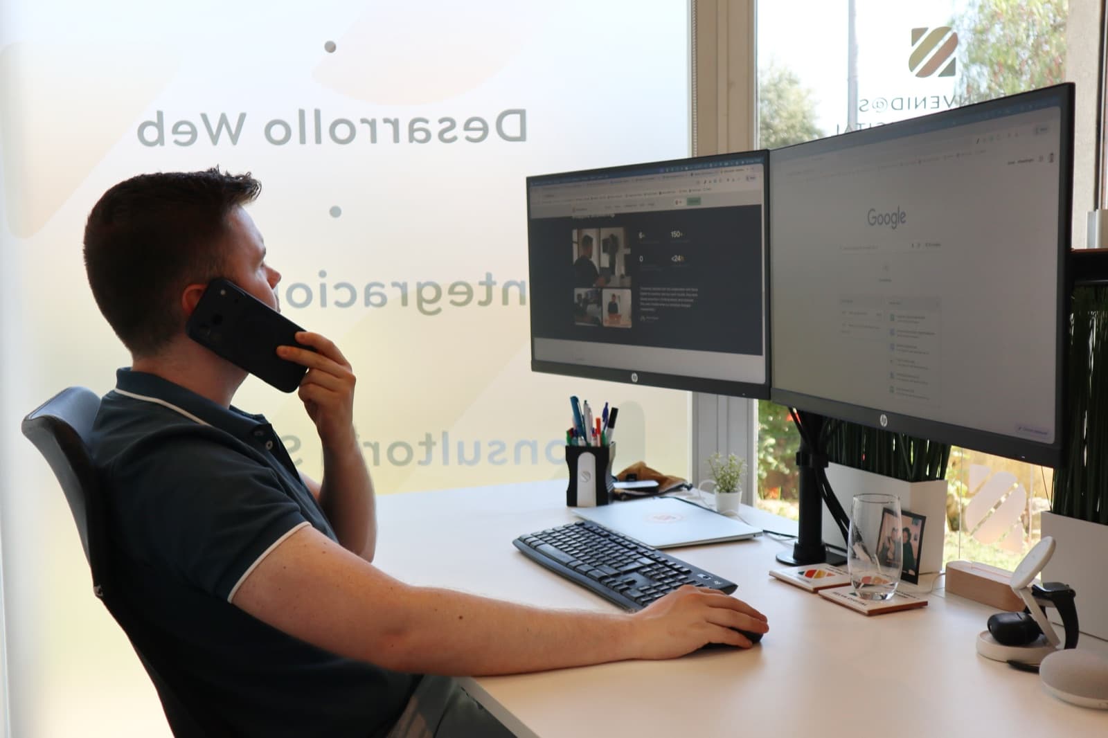 Noah on the phone at his desk, with a client's site open on two monitors