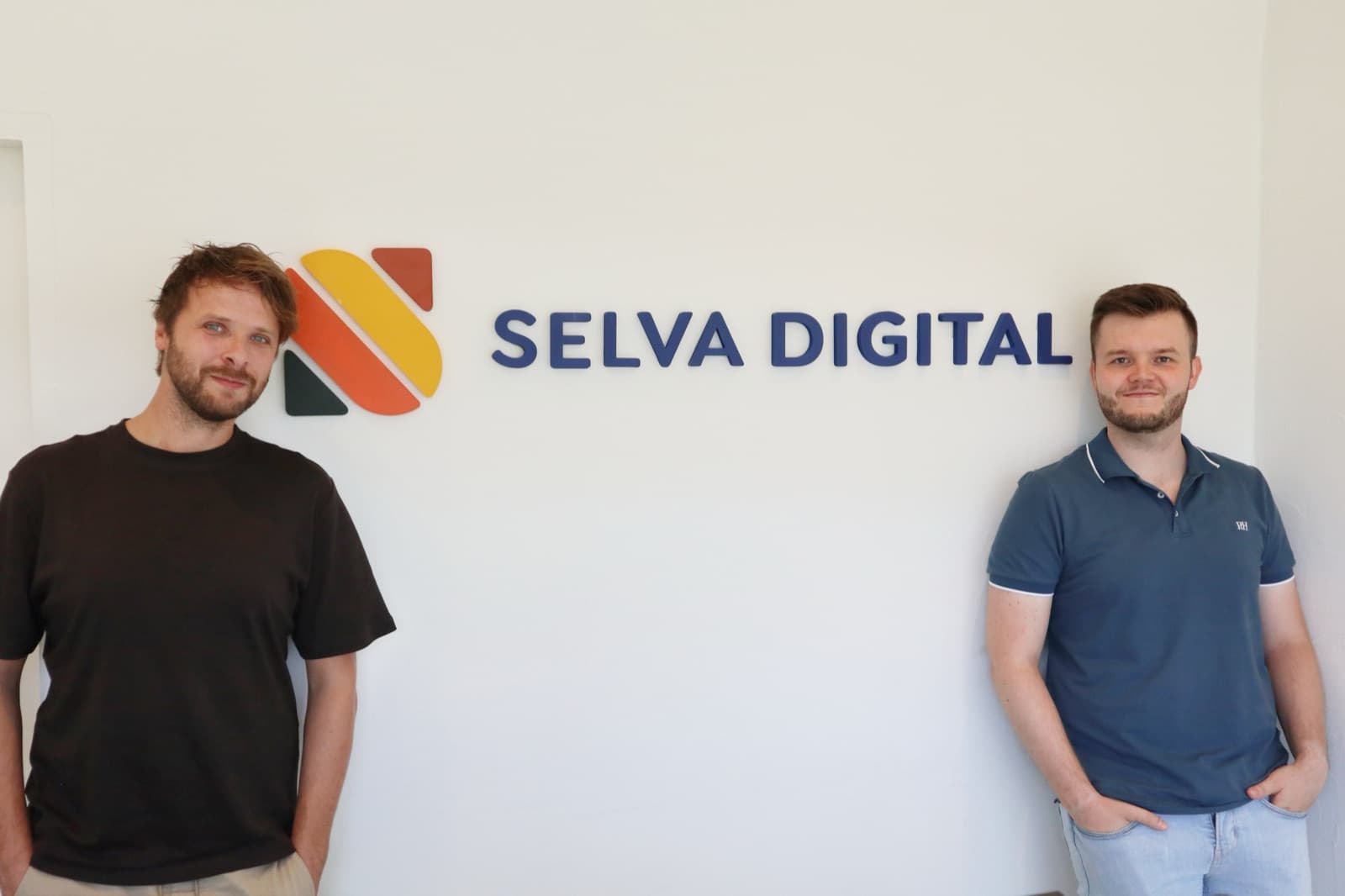 Vincent and Noah under the Selva Digital logo in the office