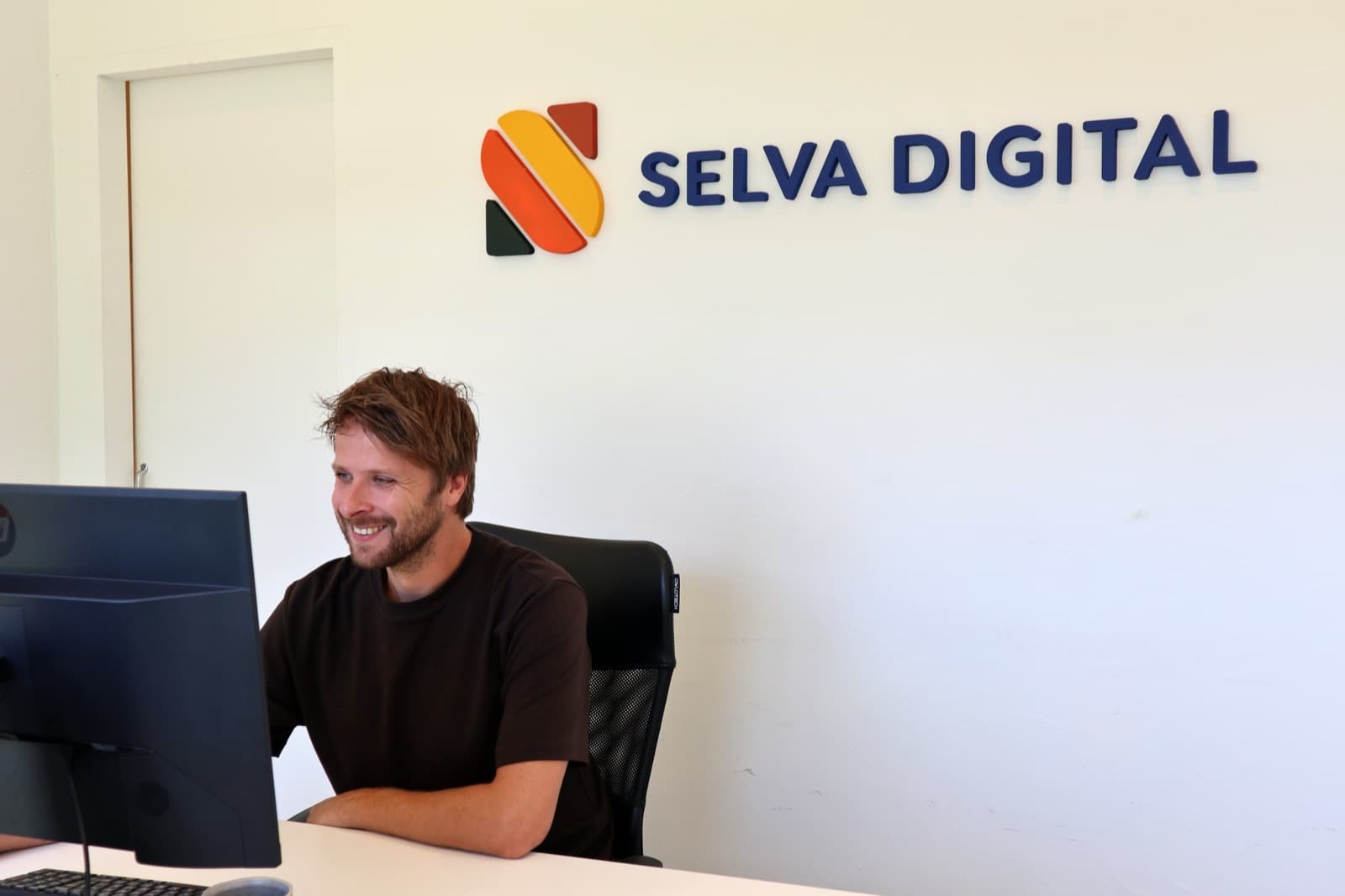 Vincent at his desk under the Selva Digital logo